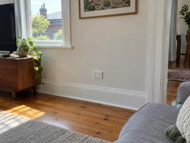 Wall power point on a cream living room wall with timber floor and window light in Crows Nest